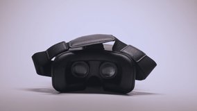 Movie playing inside virtual reality device at white background. Close-up of black VR goggles with blinking light. Technology concept. 4k UHD video
