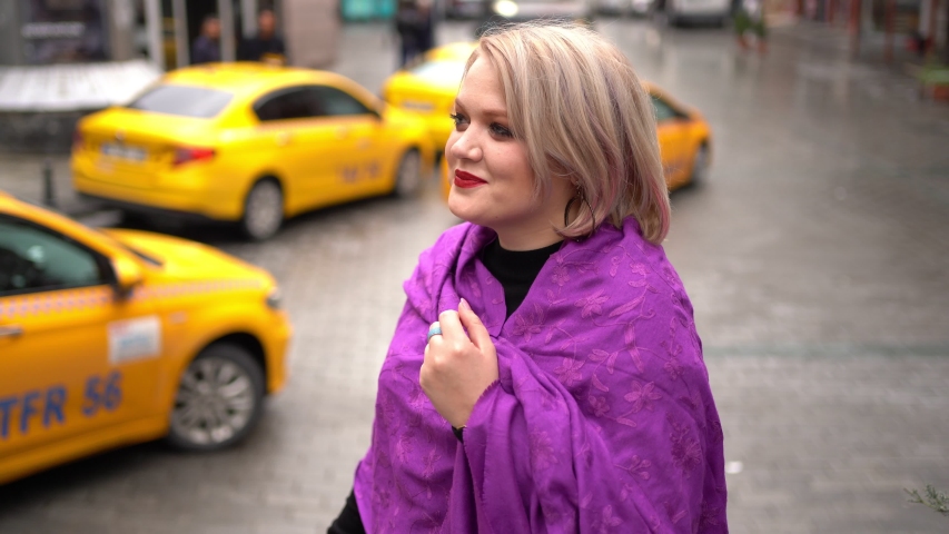 Blonde with red lips on a background of yellow taxis and cars