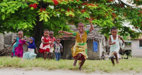 Authentic shot of happy carefree rural african kids friends are having fun to run and laughing in a sunny day on a village background. Concept: freedom, charity ,life, happiness, authenticity, friends