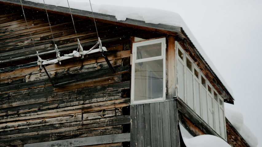 Winter landscape. Exterior view of wooden home covered with snow in Russian village located in Siberia. Russia. 4K