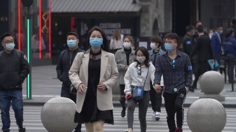 Chengdu, Sichuan/China-March 4th 2020: slow motion of people wear protective mask walking in the street at Chunxi road commercial town as coronavirus Covid-19 outbreak