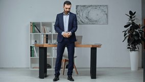 handsome businessman exercising while standing near workplace in office