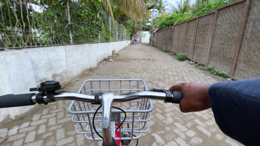 FPV of riding a bicycle with one hand in Gili Islands, Indonesia
