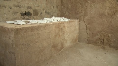 Empty Tomb after the Resurrection of Jesus Christ at Easter - He is risen. Only the grave clothes left. Tracking Shot. Stock video clip footage