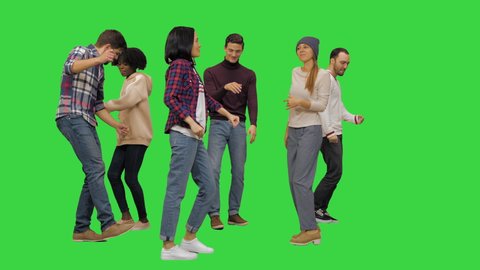 Group of happy young people dancing together on a Green Screen, Chroma Key.
