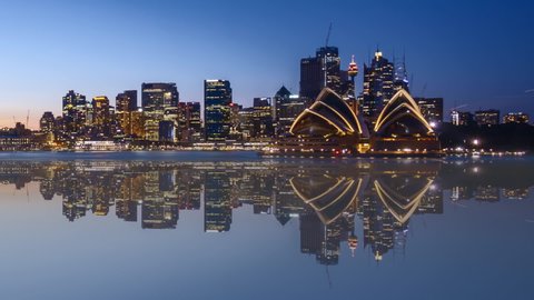 Time lapse of beautiful Sydney city skyline with water reflection effect, from sunset to sunrise (day to night to day). Zoom out