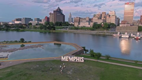 Aerial: people having their photo taken at The MEMPHIS Sign on Mud Island River Park. In the background is downtown Memphis, Tennessee, USA. 26 June 2019 
