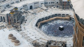 Time lapse sunset of Muslim pilgrims circling around the holy Kaaba at day and praying inside al Masjid al Haram in Mecca, Saudi Arabia. Zoom in motion