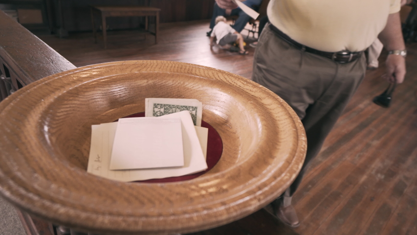 Man puts money in offering plate | Shutterstock HD Video #1047803389