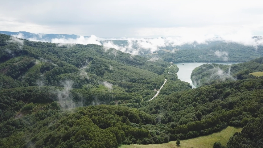 Clouds of fog after summer rain. Summer landscape with lake and mountain woodland. Aerial view of Reservoir/lake Starina, Poloniny national park, Slovakia.