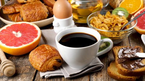 breakfast with coffee cup, croissant, bread, cornflakes and fruits