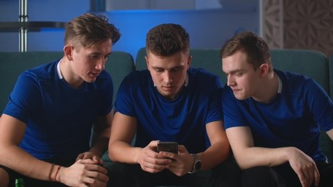 Excited 3 man winner holding using smartphone feeling overjoyed with mobile online bet bid gambling game win, happy three friends euphoric looking at cell phone celebrate good news victory success.