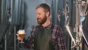 Portrait. An adult male brewer checks the color of freshly brewed beer from a beer tank while standing in a beer factory. - Powered by Shutterstock - Get 15% off with code: PIKWIZARD15