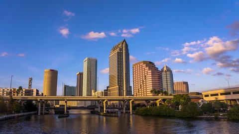 Tampa, Florida, USA - January 11, 2020 : Timelapse of a colorful sunset above Tampa skyline with Hillsborough river in the foreground. 4K UHD video.