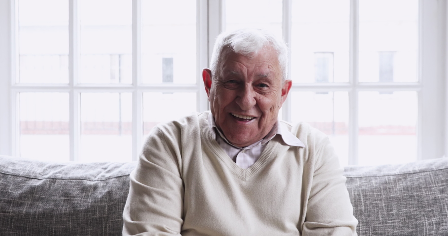 Happy senior 80s grandfather look talk to camera at home video calling recording vlog, smiling elderly adult man sit on sofa communicate in online chat, webcam view, old people making videocall | Shutterstock HD Video #1047837505