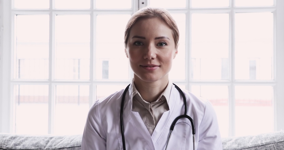 Smiling young female doctor wear white uniform stethoscope consulting online patient via video call looking at camera speaking cam do distance video chat, telemedicine and e-health concept, webcam Royalty-Free Stock Footage #1047837529
