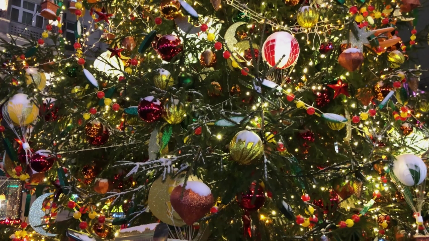 Tall christmas tree at market decorated and illuminated outdoors, panorama from bottom to top
