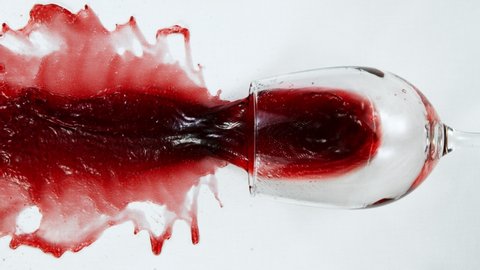 Super Slow Motion Top Shot of Falling Glass with Red Wine on White Cloth at 1000fps.