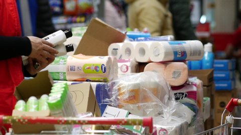 Moscow, Russia - March 5, 2020: Pyaterochka supermarket. Large packaging with toilet paper and paper towels. Big choice. Merchandiser in trading floor unpacks the goods for laying out on the shelves.