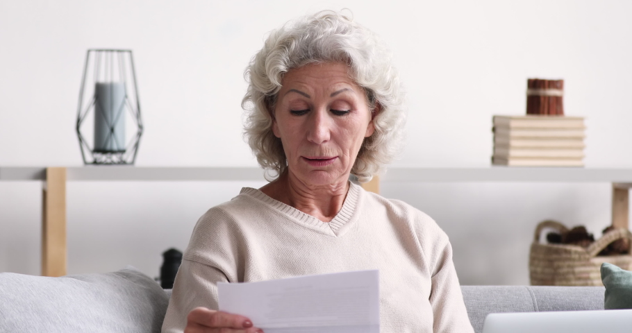 Shocked upset senior woman reading bad news in post mail letter. Frustrated retired grandma holding bill looking worried about dept, troubled with bankruptcy. Unhappy old lady feels bad surprise Royalty-Free Stock Footage #1047858481