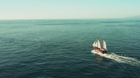 A pirate sailboat in the open ocean rushes towards adventure