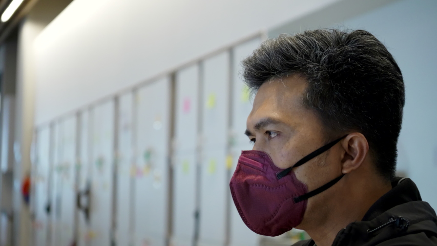 Asian businessmen aged 45-55 wear standard protective masks Work at a modern office. Put on a protective mask and Safety Pm2.5 dust, coronavirus and spread to people or colleagues. Health concepts | Shutterstock HD Video #1047863911