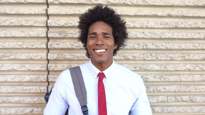 Happy Black man smiling outdoors. Smiling guy with afro hair. Slow motion. Royalty-Free Stock Footage #1047866215