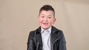 The boy gives an interview on camera, the child speaks to the camera and laughs