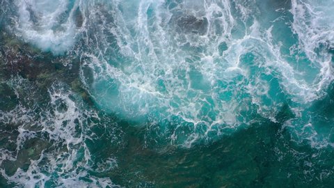 Aerial view of the ocean surface near the rocky coast off the island of Tenenife, Canary Islands, Spain. Aerial drone footage of sea waves reaching shore
