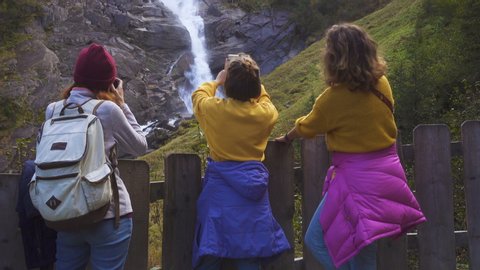 tourist girls looking at the Krimml Waterfalls from the viewpoint

