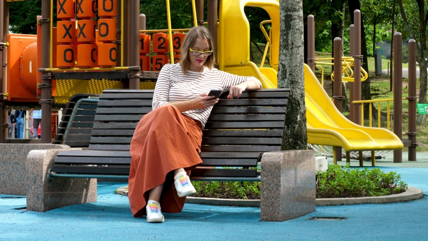 Casual female talks to smartphone using voice recognition outdoor. Voice talk message in social networks. Business, technology, communication concept 