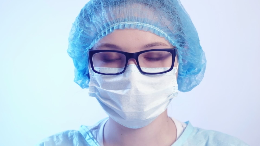 Medical worker portrait. Confident female doctor in protective face mask and eyeglasses. Royalty-Free Stock Footage #1047913333