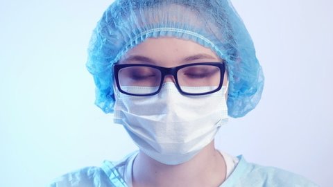 Medical worker portrait. Confident female doctor in protective face mask and eyeglasses.