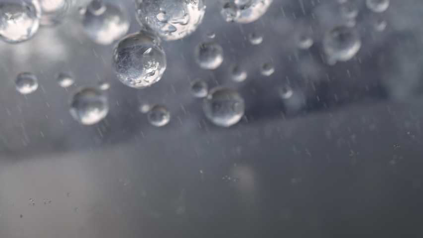 A photo from inside the house of the rain outside the window, a drop of water on the bokeh glass. Мелкие капли на стекле. Дождь вертикаль для детей. Raindrop falling. Капли дождя на воде.