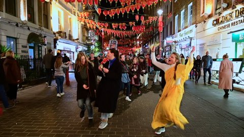 LONDON, UK - MARCH 7 2020: Hare Krishnas dance through Chinatown in London's Soho.