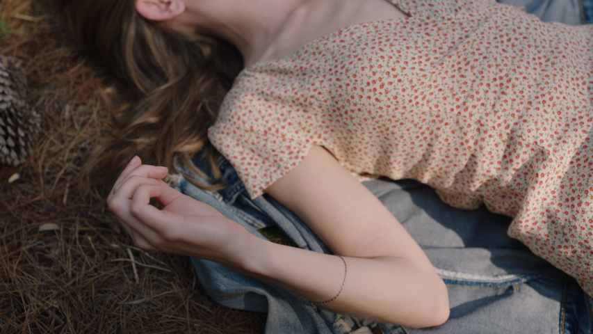 nature girl playing with hair lying on ground in forest daydreaming relaxing in woods