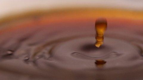 Close-up of Espresso coffee drop into the filled Cup from the coffee machine in slow motion