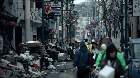 Fukushima, Japan - 03/11/2011 : people clean the debris in the middle of a street, after the tsunami