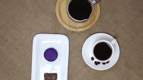 Top view spinning video of coffee pot with cup with candies. FHD.