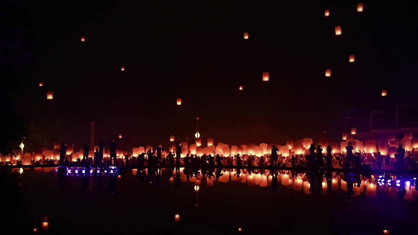 thousands of floating fire paper lanterns in the night sky with reflection in the pool at yee peng festival. Loy Krathong celebration, Chiangmai, Thailand Royalty-Free Stock Footage #1047988699