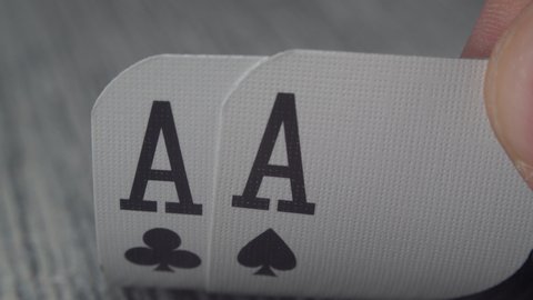 Low angle closeup view of a male hand picking up and showing cards from a casino table