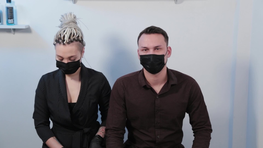 Young man and woman in protective masks.