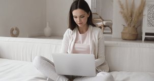 Euphoric young woman user celebrate success winning on laptop sitting on couch. Excited girl using computer receiving great email news at home. Internet luck and online victory for customer concept