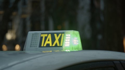 Close-up shot of vacant taxi sign on the roof, car is leaving