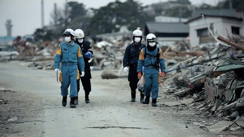Fukushima, Japan - 03/11/2011 : rescue team walk in the streets to search victims in the ruins of the city after the tsunami