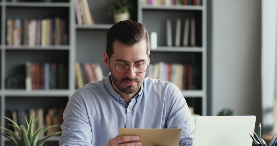 Angry stressed businessman opening envelope reading bad news in mail letter. Mad man feels frustrated about high bills, dismissal notice, bank debt, tax invoice or mistake sits at home office desk | Shutterstock HD Video #1048034848