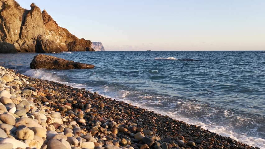 Sea shore at sunset 4K, beautiful sea surf in the sunset rays of the sun