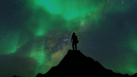 Silhouette man on hilltop with Aurora Borealis,Northern Lights or polar light in beautiful night sky over the mountain,Realistic aurora time lapse animation background.