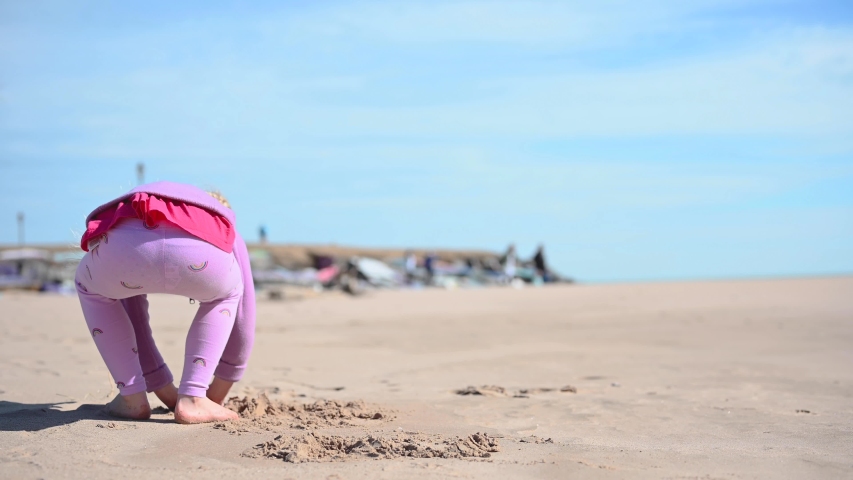 little girl playing on beach along Lake Michigan in Spring