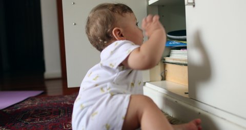 Baby infant opening cabinet furniture at home